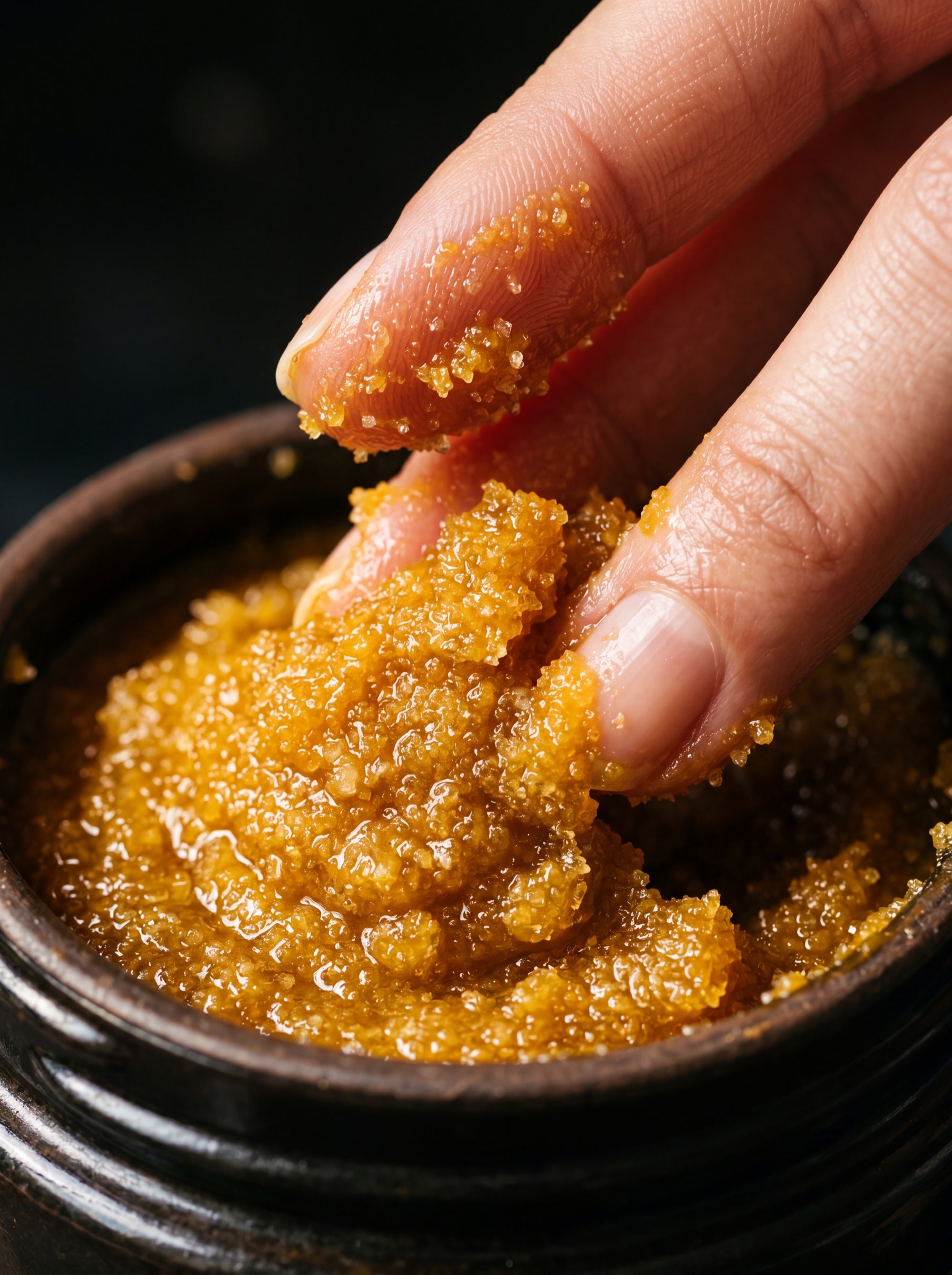 Golden turmeric scrub texture close-up - sugar granules with amber paste
